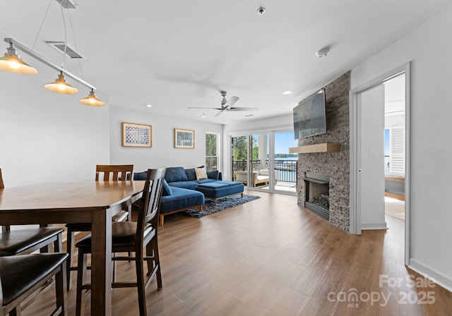 dining space featuring recessed lighting, wood finished floors, visible vents, a fireplace, and ceiling fan