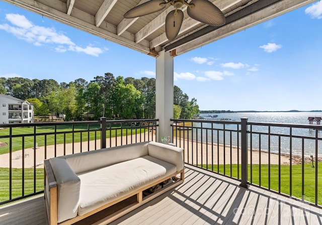 deck with a ceiling fan and a water view