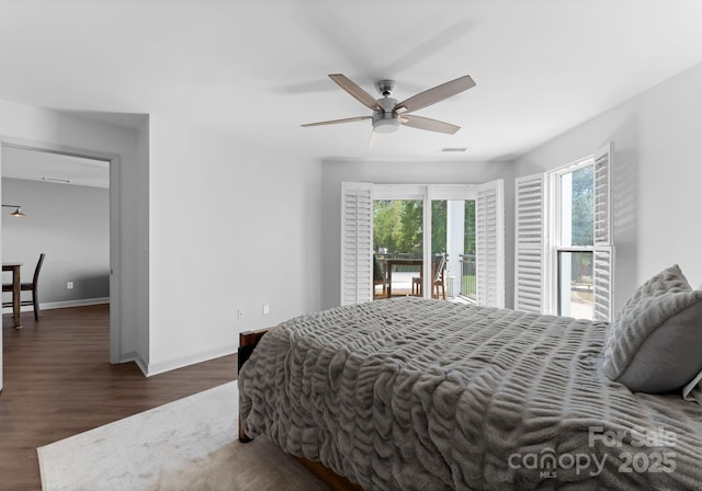 bedroom with wood finished floors, visible vents, access to outside, and multiple windows