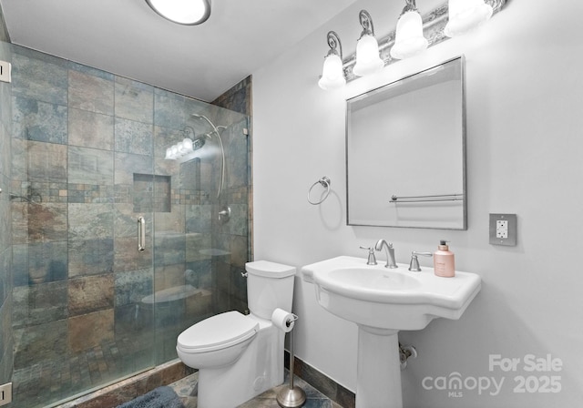 bathroom featuring toilet and a stall shower