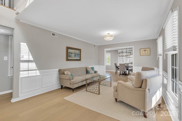 living room with crown molding and light wood-type flooring