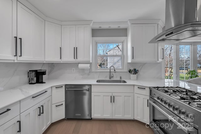 kitchen featuring extractor fan, stainless steel appliances, sink, and white cabinets