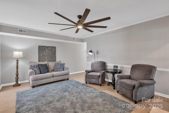 living room featuring ornamental molding, ceiling fan, and light hardwood / wood-style floors