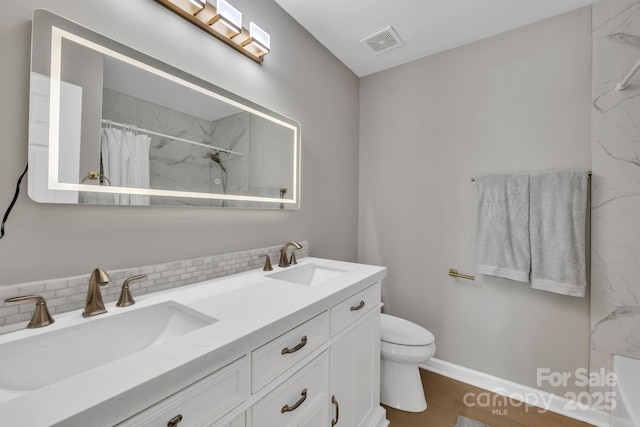 bathroom featuring hardwood / wood-style floors, a shower with shower curtain, tasteful backsplash, vanity, and toilet