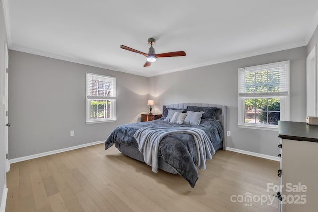 bedroom with crown molding, multiple windows, and light wood-type flooring