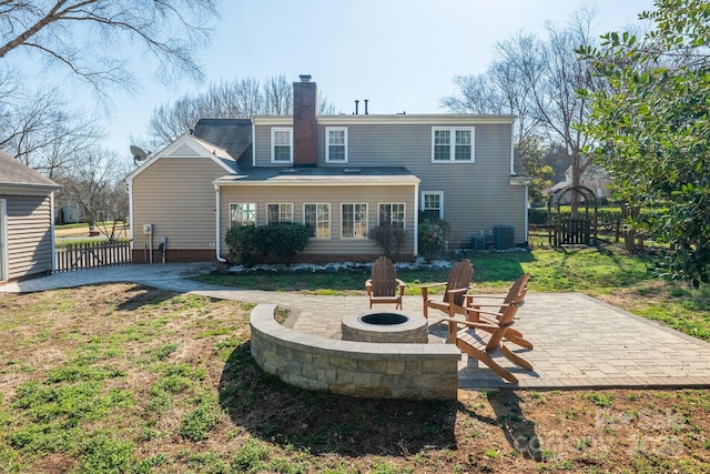 back of property with an outdoor fire pit, a yard, and a patio area