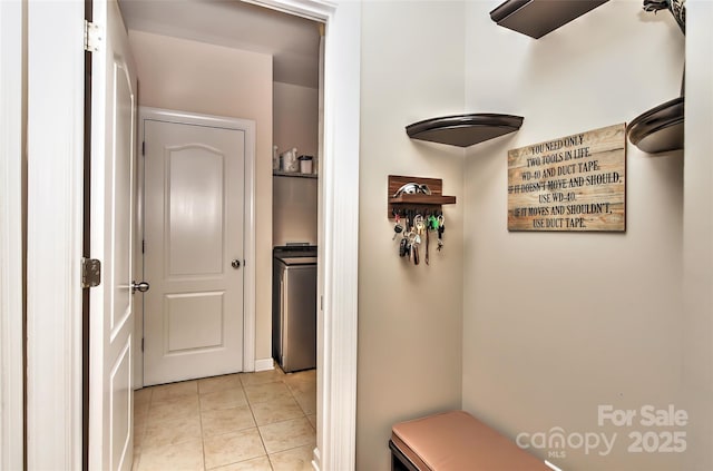 hallway with light tile patterned flooring and washer / clothes dryer