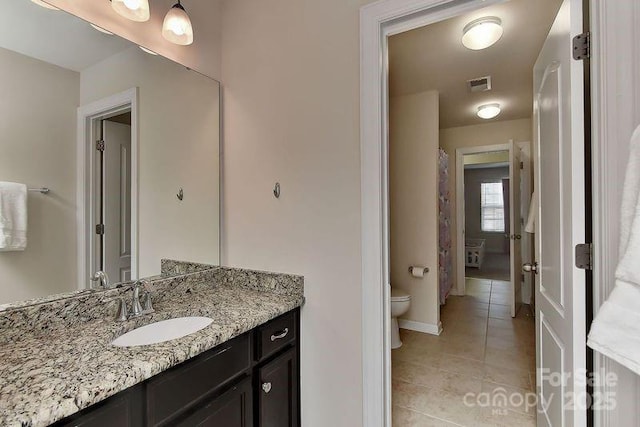 bathroom with tile patterned floors, vanity, and toilet