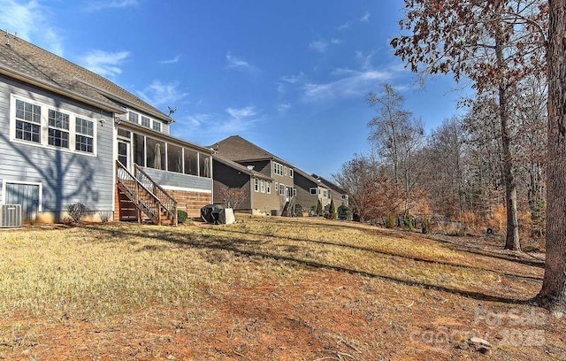 view of yard with cooling unit and a sunroom