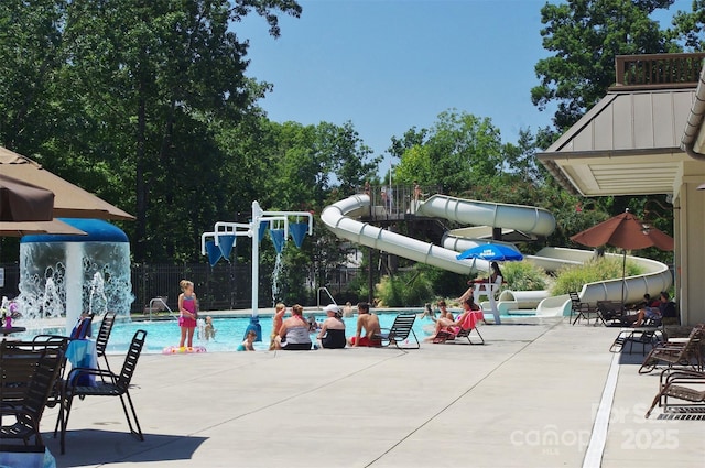 view of pool with pool water feature, a water slide, and a patio area