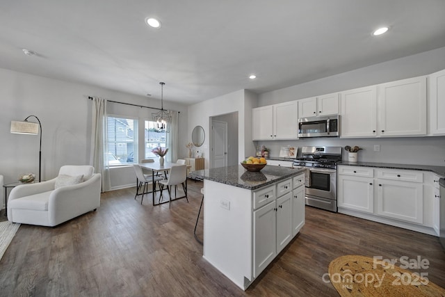 kitchen with stainless steel appliances, a kitchen island, and white cabinets