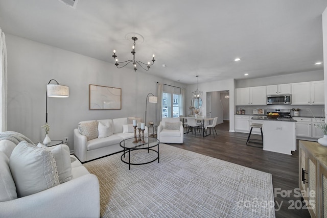 living room with dark hardwood / wood-style floors and a chandelier