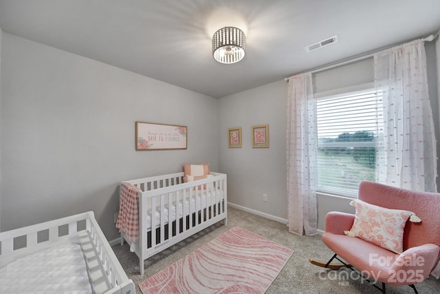 carpeted bedroom featuring a nursery area