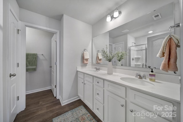 bathroom with hardwood / wood-style flooring, vanity, and walk in shower