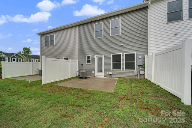 rear view of house featuring central AC unit, a yard, and a patio