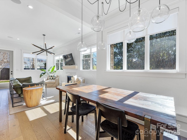 dining area with ornamental molding, a chandelier, and light hardwood / wood-style flooring