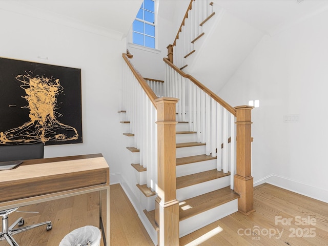 stairs with a high ceiling and hardwood / wood-style floors