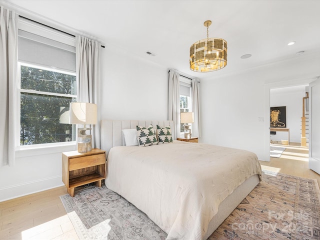 bedroom with an inviting chandelier and light wood-type flooring