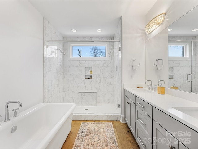 bathroom with independent shower and bath, vanity, and hardwood / wood-style floors