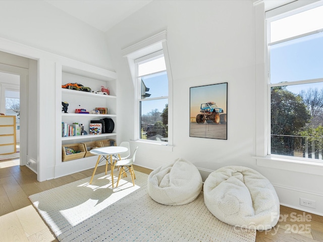 sitting room featuring hardwood / wood-style flooring and built in features