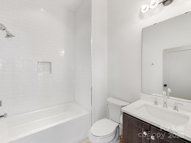 full bathroom featuring tiled shower / bath combo, vanity, and toilet