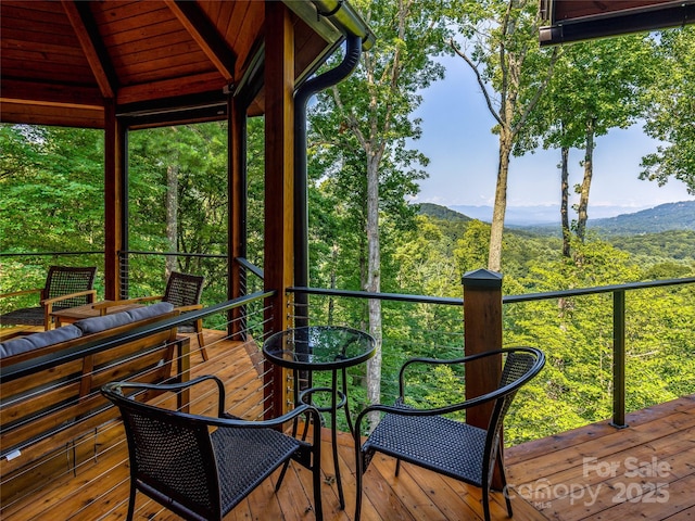 deck with a forest view and a mountain view