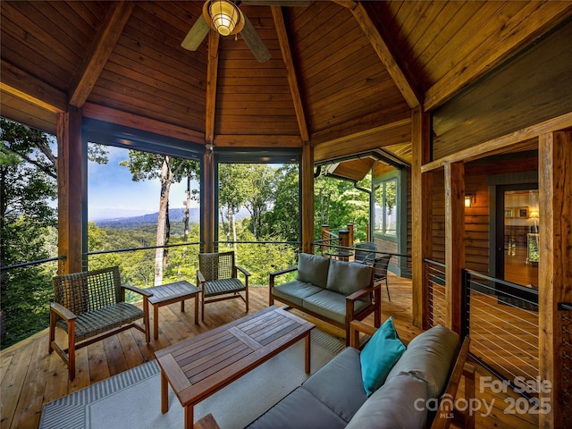 sunroom with a healthy amount of sunlight, vaulted ceiling with beams, wood ceiling, and ceiling fan