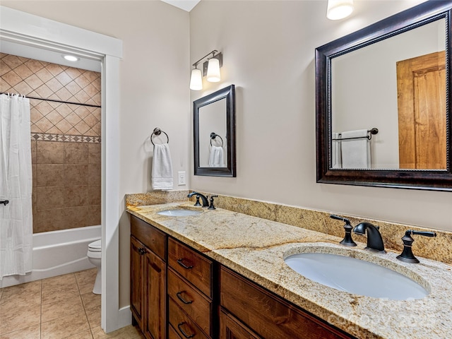 bathroom with double vanity, tile patterned flooring, toilet, and a sink