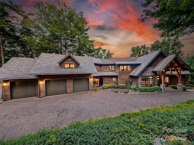 view of front facade featuring an attached garage, decorative driveway, and roof with shingles