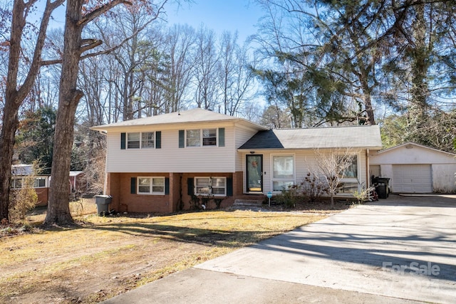 split level home featuring a garage, an outdoor structure, and a front lawn