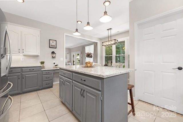 3300 Chancellor Ln, Monroe, NC 28110 - kitchen featuring gray cabinetry, freestanding refrigerator, white cabinets, a kitchen breakfast bar, and light tile patterned floors