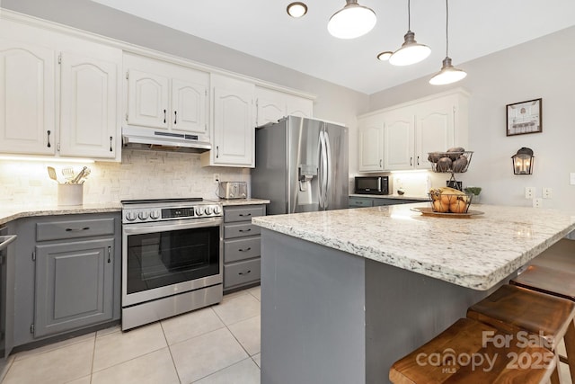 3300 Chancellor Ln, Monroe, NC 28110 - kitchen with stainless steel appliances, gray cabinets, under cabinet range hood, white cabinets, and a breakfast bar area