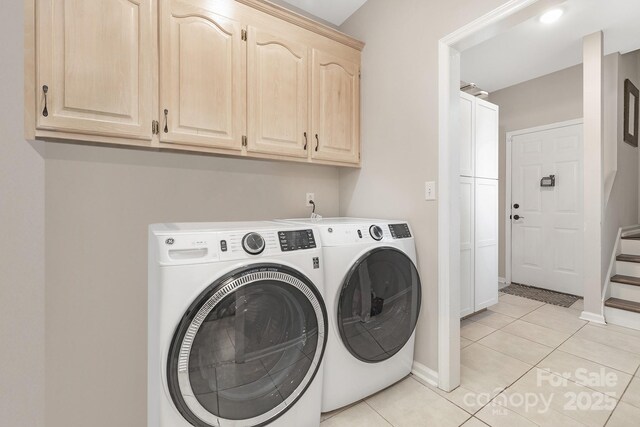 3300 Chancellor Ln, Monroe, NC 28110 - washroom featuring washer and clothes dryer, cabinet space, light tile patterned floors, and baseboards