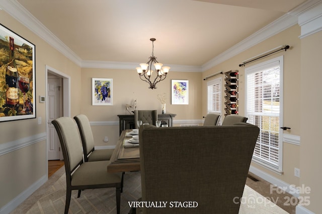 dining room with crown molding and a chandelier