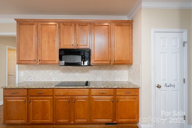 kitchen with ornamental molding, light stone countertops, decorative backsplash, and black appliances