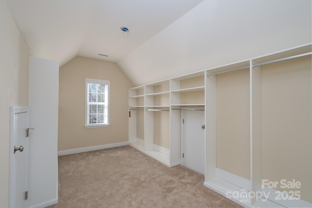 spacious closet featuring lofted ceiling and light carpet