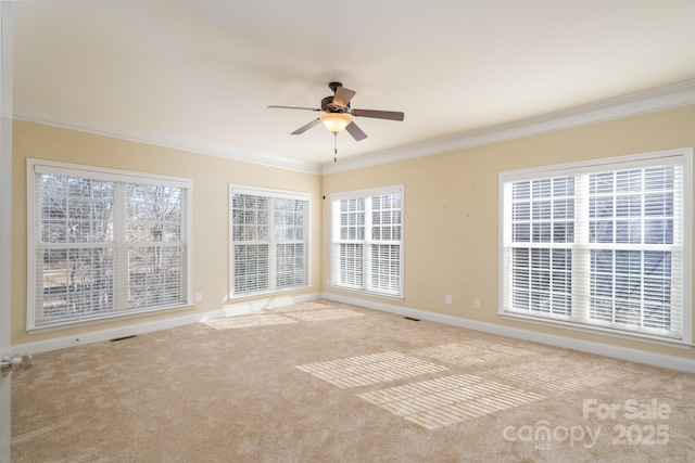 carpeted empty room featuring crown molding, ceiling fan, and a healthy amount of sunlight