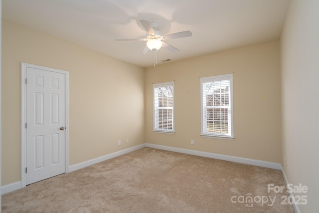 spare room featuring light colored carpet and ceiling fan