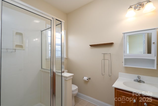 bathroom featuring tile patterned floors, vanity, toilet, and a shower with shower door