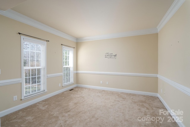 empty room featuring crown molding and light carpet