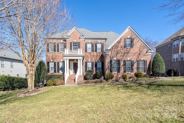 colonial home with a front yard and a balcony