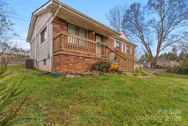 exterior space featuring cooling unit and a lawn