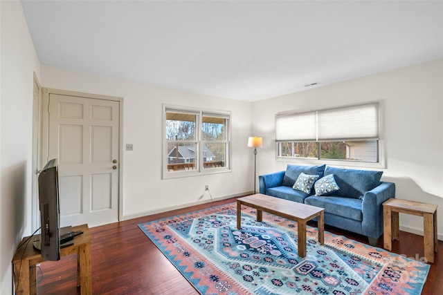 living room with plenty of natural light and dark hardwood / wood-style floors