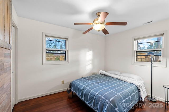 bedroom with dark hardwood / wood-style floors and ceiling fan