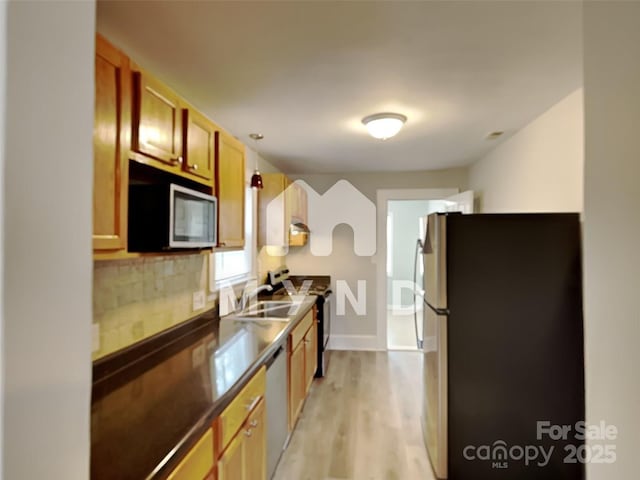 kitchen featuring sink, decorative backsplash, stainless steel appliances, and light hardwood / wood-style floors