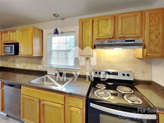 kitchen with decorative backsplash, appliances with stainless steel finishes, sink, and hanging light fixtures