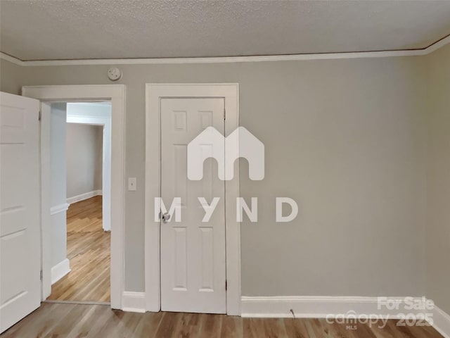 details with hardwood / wood-style floors, ornamental molding, and a textured ceiling