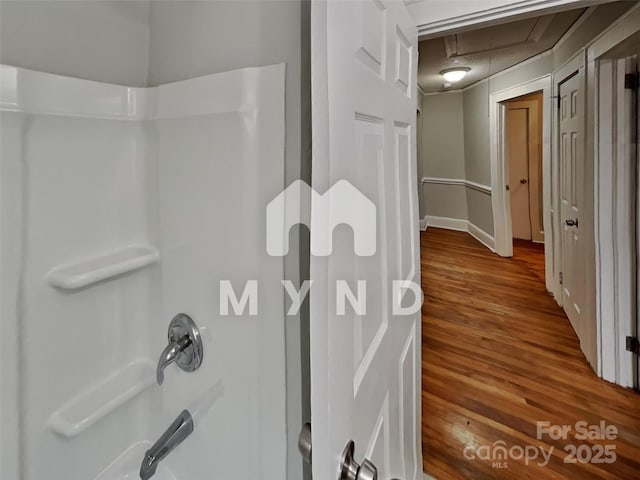 bathroom featuring wood-type flooring and shower / bathtub combination