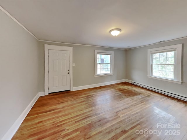 entrance foyer with a baseboard heating unit, light hardwood / wood-style flooring, and ornamental molding