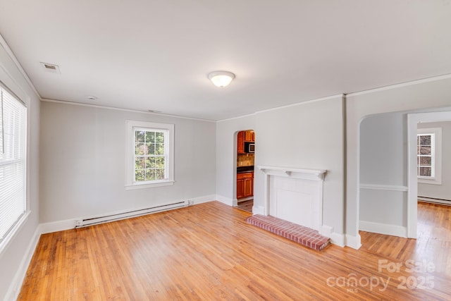 unfurnished room featuring light wood-type flooring, visible vents, arched walkways, baseboards, and baseboard heating